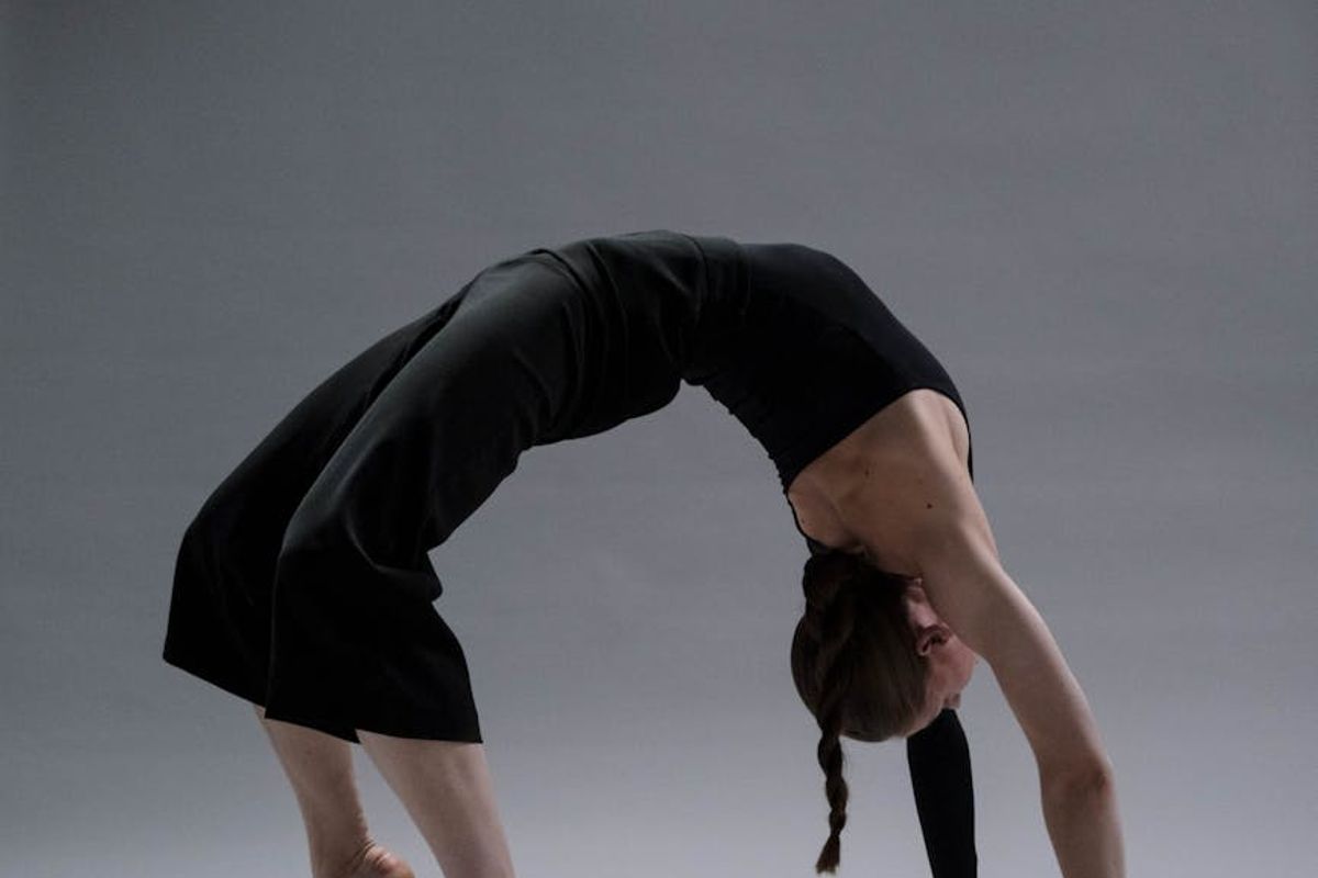 Person practicing a standing yoga pose in shadows